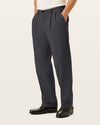 Side view of model wearing Black Easy Stretch Khakis, Pleated, Relaxed Fit.